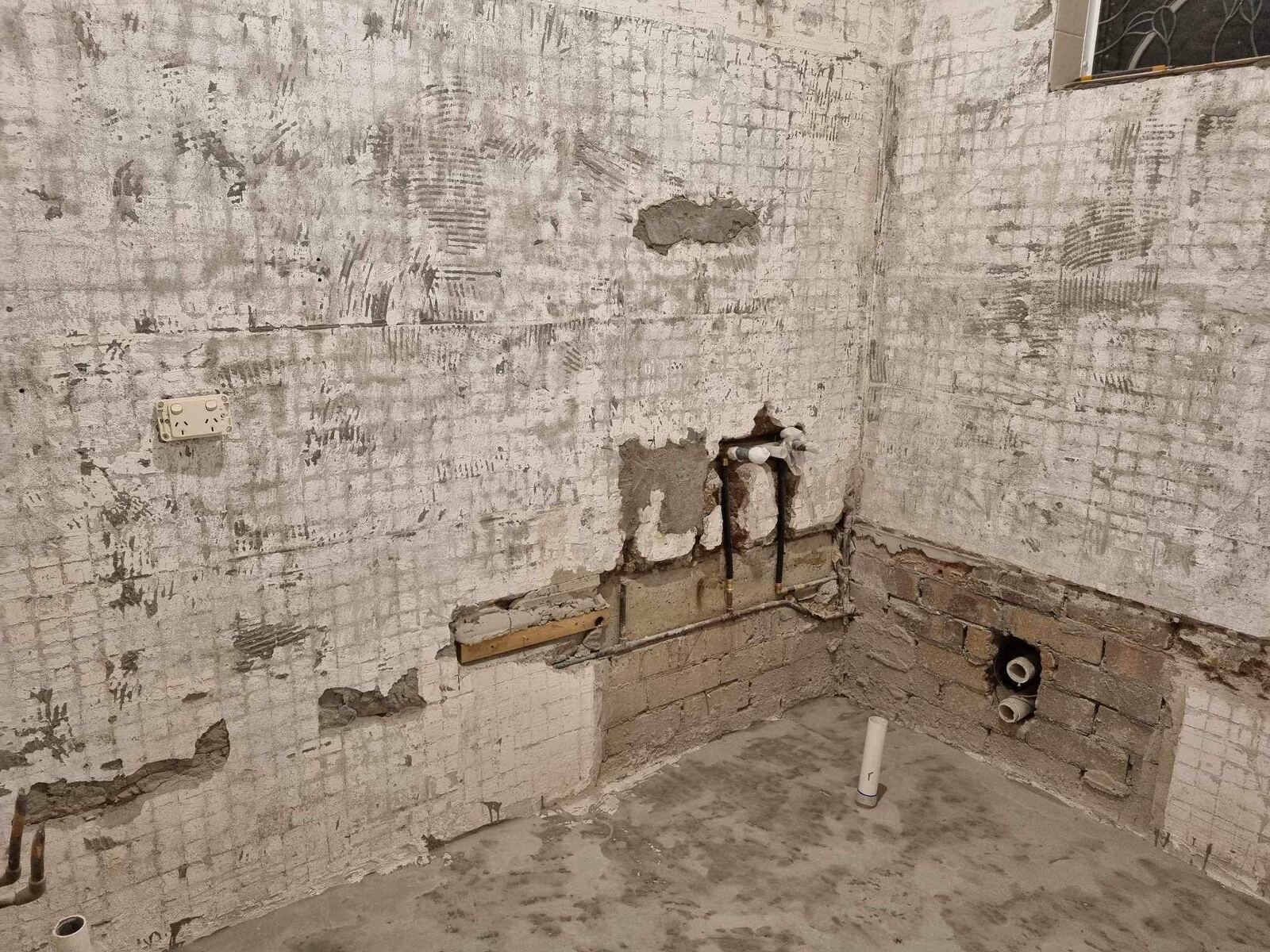 Bathroom stripped back to brick with rough-in pipework